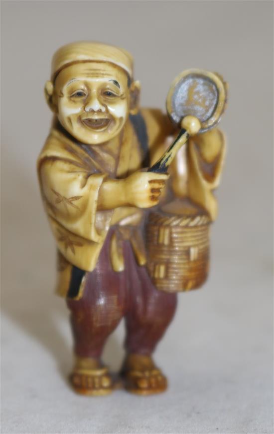 A Japanese tinted ivory figure of a street vendor, Taisho period, 5cm